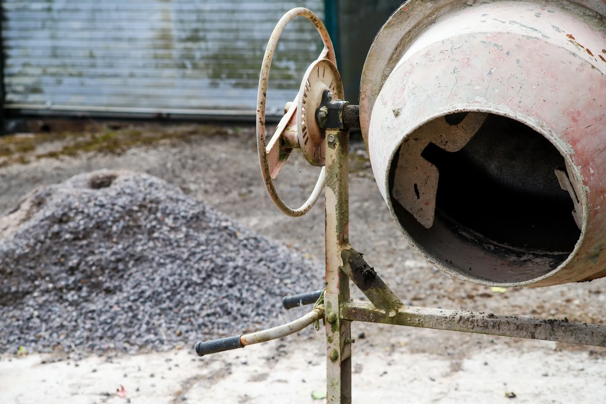 Portable cement mixer beside a gravel pile